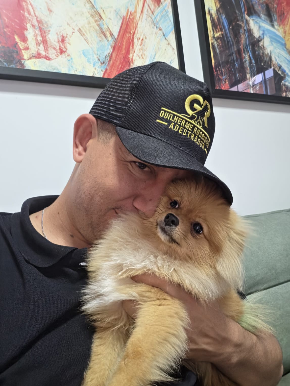 Guilherme Rodrigues segurando um lulu da pomerânia no colo
